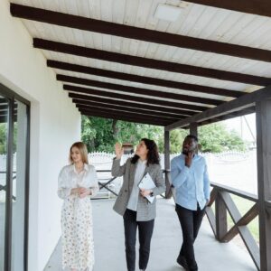 Real estate agent showing house to clients during walk-through on a porch.